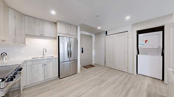 A modern kitchen with white cabinets and stainless steel appliances.