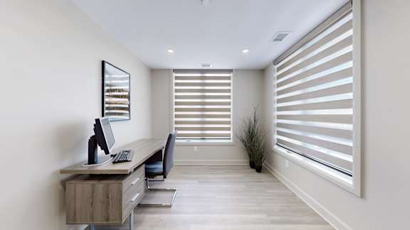 A room with a desk and a computer monitor.