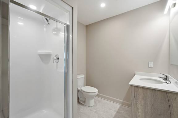 A bathroom with a toilet, sink, and shower.