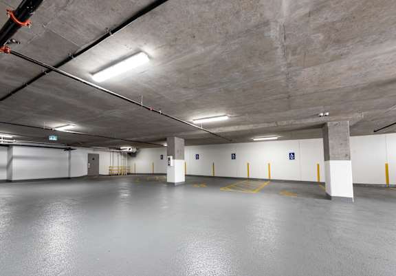 an empty parking garage with white walls and concrete floors