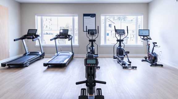A gym with treadmills, exercise bikes, and elliptical machines.