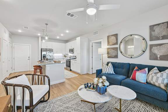 A modern living room with a blue couch and a coffee table.at Allegra at Cocoa in Cocoa, FL, 32926