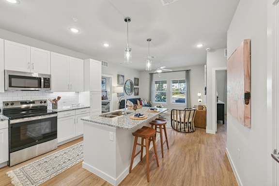A kitchen with white cabinets and a large island.at Allegra at Cocoa in Cocoa, FL, 32926