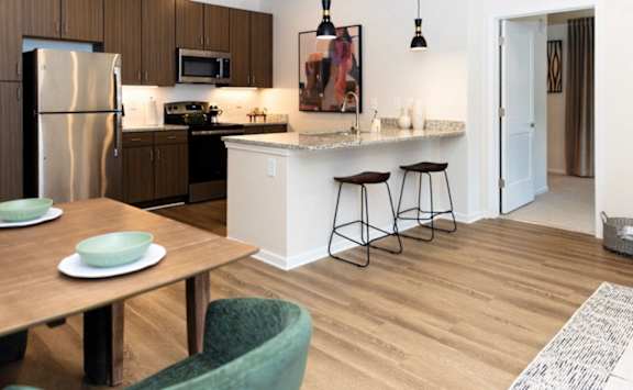 A kitchen with a table and chairs in front of it.