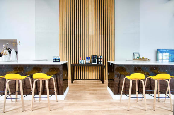 a cafe with yellow chairs and marble counters and wood floors at Presidio Palms Apartments, Tucson, AZ