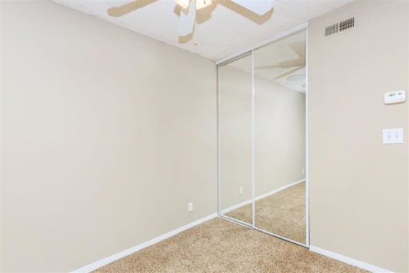 a room with a ceiling fan and a mirror