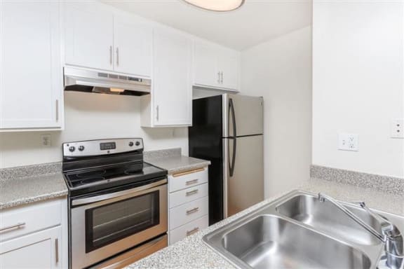 a kitchen with a stove refrigerator and sink