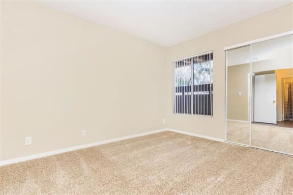 a bedroom with a large window and a mirror