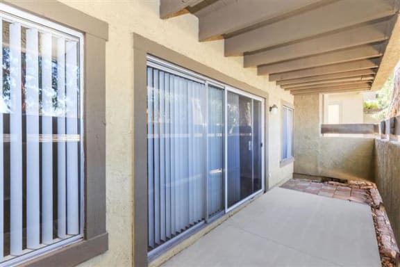 a patio with a sliding glass door and windows
