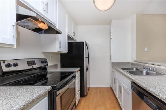 a kitchen with white cabinets and black appliances