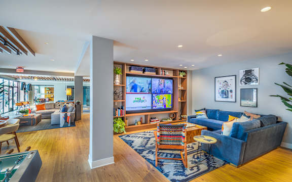 Community lounge with entertainment center and sectional seating at Inwood at Renaissance Square Apartments, New Jersey, 08053