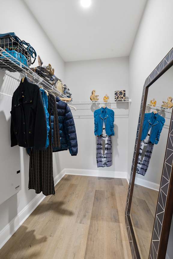 A row of coats are hanging on a rack in a room.