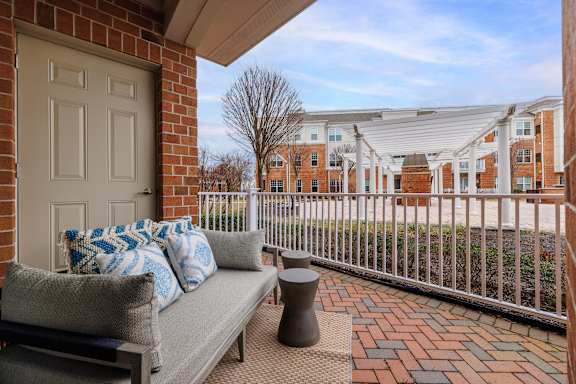 A patio with a couch and pillows is shown.