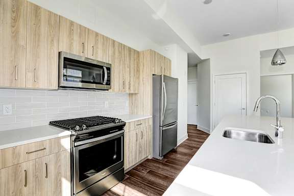 Modern kitchen with stainless steel appliances and wood cabinetry at Inwood at Renaissance Square Apartments, New Jersey
