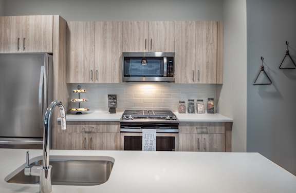 Kitchen island with sink and view of stove at Inwood at Renaissance Square Apartments, New Jersey