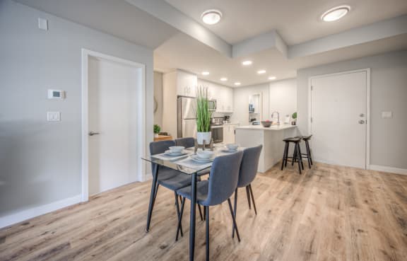 a dining room with a table and chairs and a kitchen