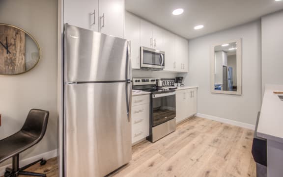 a kitchen with stainless steel appliances and white cabinets