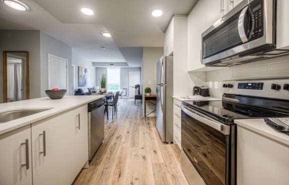an open kitchen with stainless steel appliances and white cabinets