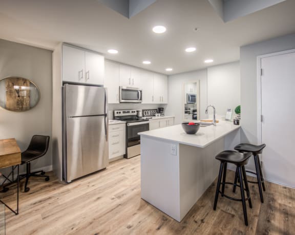 a kitchen with a large island and stainless steel appliances