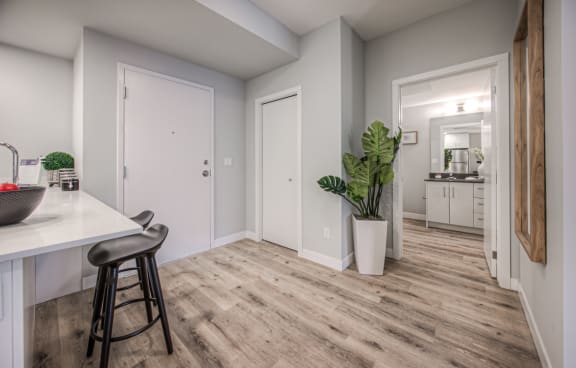 an open kitchen and living room with wood flooring and white walls
