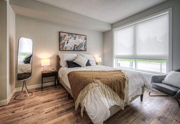 a bedroom with a bed and a mirror on the wall