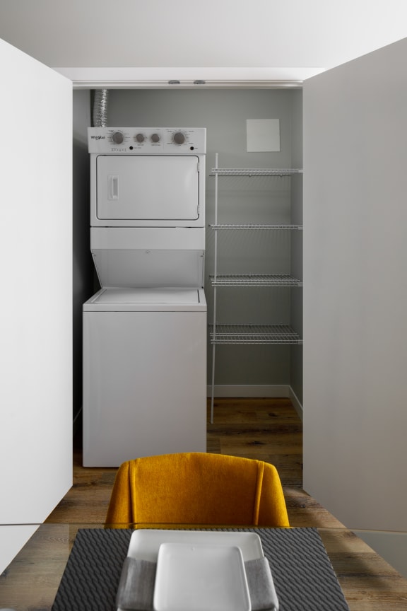 a white washer and dryer in a small room next to a closet