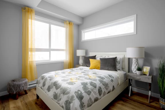 a bedroom with a bed and two windows with yellow curtains