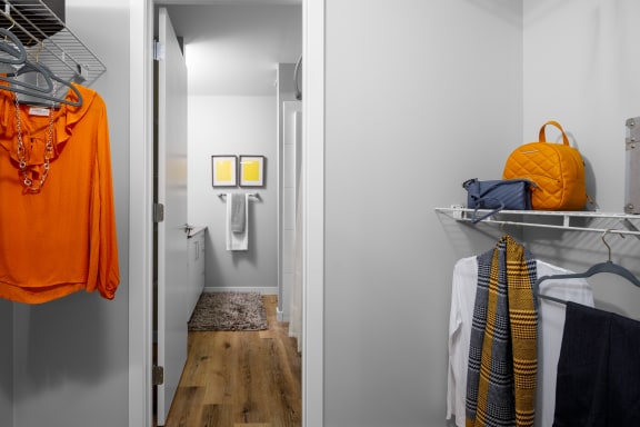 a small bedroom with a closet and a hallway with a laundry room