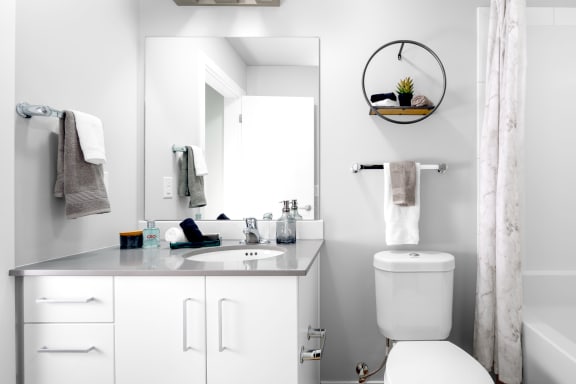 a white bathroom with a white toilet and a sink