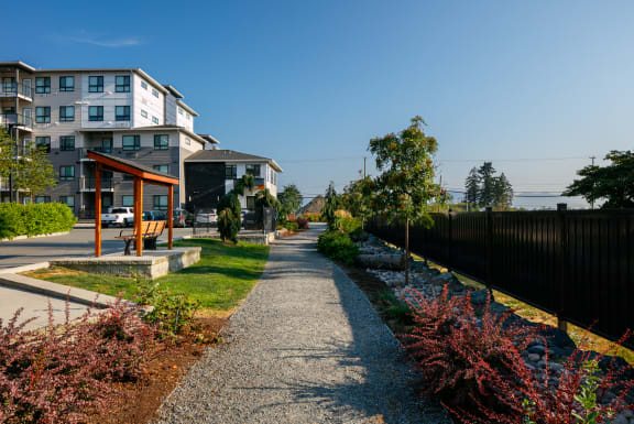 a path leading to a house with a yard and a sidewalk