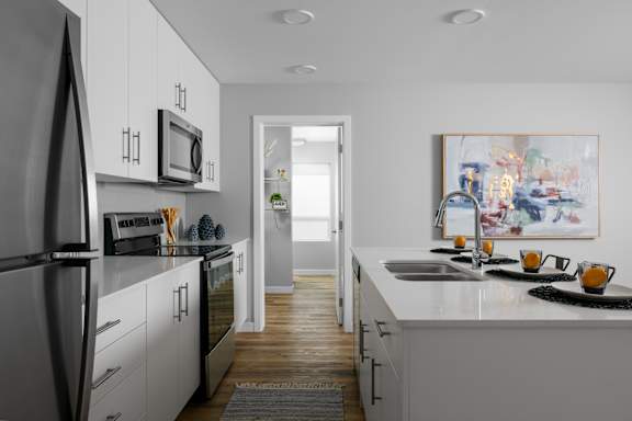 A modern kitchen with white cabinets and a refrigerator.
