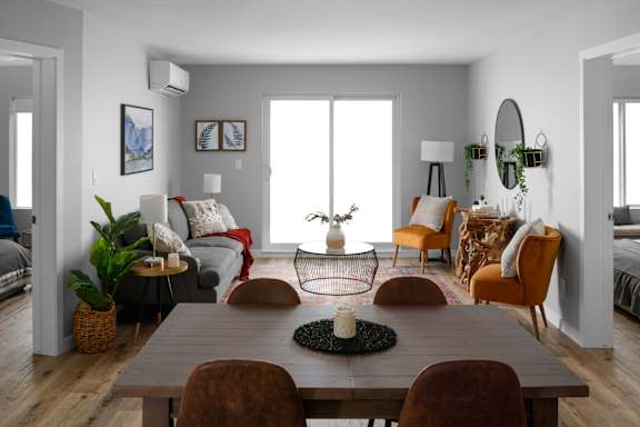 A modern dining room with a wooden table and chairs.