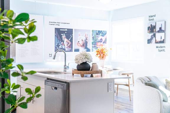 A kitchen with a white dishwasher and a poster on the wall.