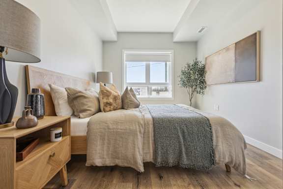A bedroom with a bed, nightstand, and lamp.