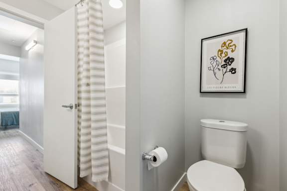 A white toilet sits next to a white door in a bathroom.