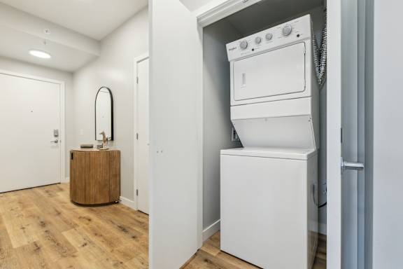 A white washing machine is in a small laundry room.