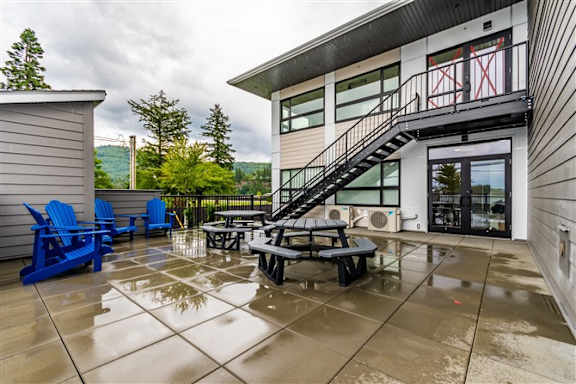 A patio with a table and chairs is in front of a house.