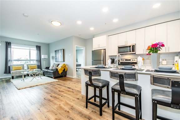 A kitchen with a bar stool in front of it.