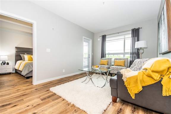 A living room with a grey couch and a yellow throw blanket.