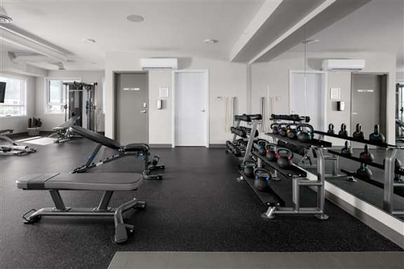 A gym with a variety of equipment including weights and weight machines.