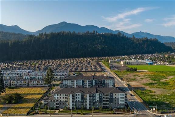 A large residential area with apartment buildings and a mountain range in the background.