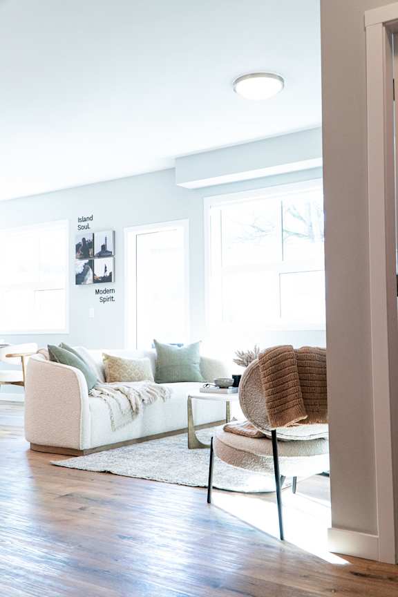 A modern living room with a white couch and a chair.