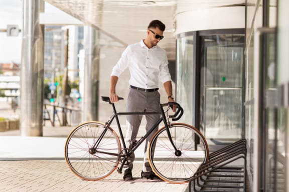 man standing with a bicycle in front of a building