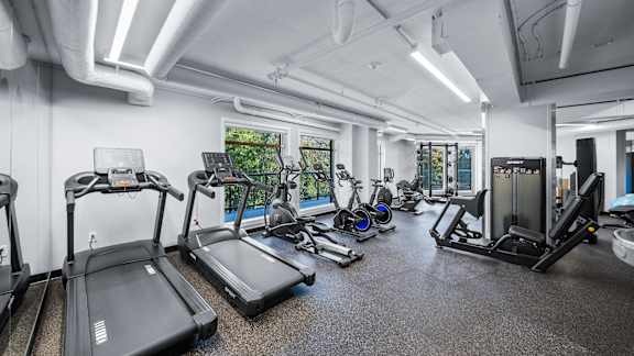 A gym with treadmills, elliptical machines, and other exercise equipment.