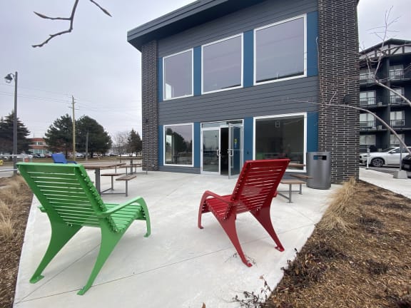 two red and green chairs in front of a building