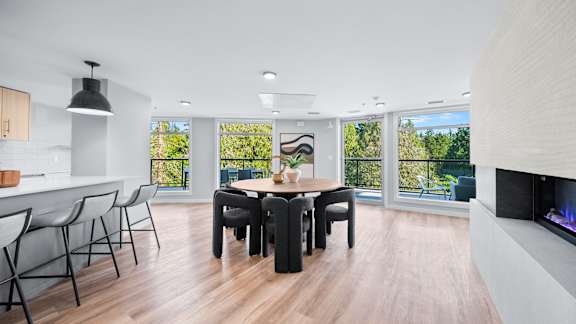 A modern dining room with a wooden table and chairs.