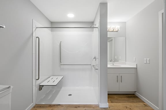 A white bathroom with a walk-in shower and a toilet.