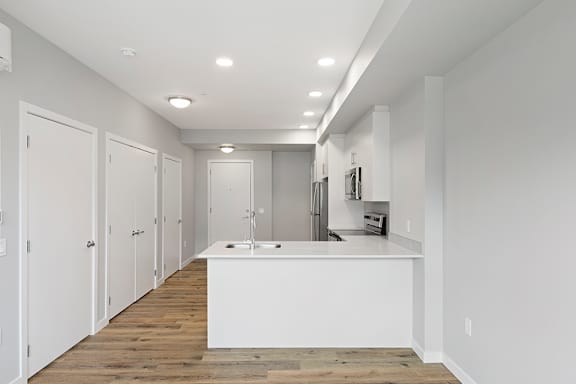 A kitchen with white cabinets and a white island.