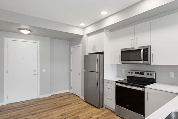 A kitchen with a stove, oven, refrigerator, and microwave.