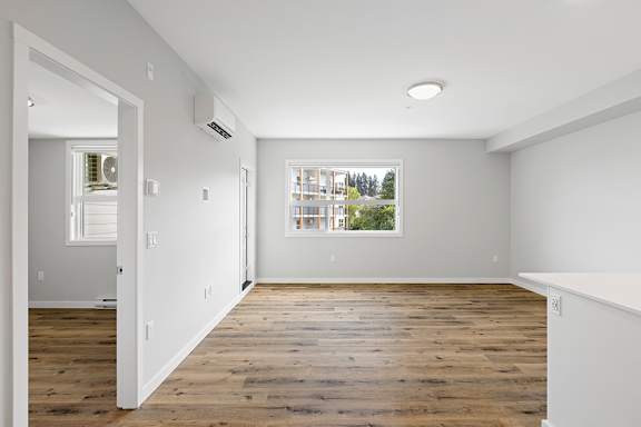 A room with a window and a wooden floor.